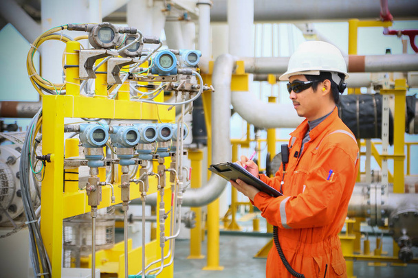 operator recording operation of oil and gas process at oil and rig plant, offshore oil and gas industry, offshore oil and rig in the sea, operator monitor production process, routine daily record. - Photo, Image