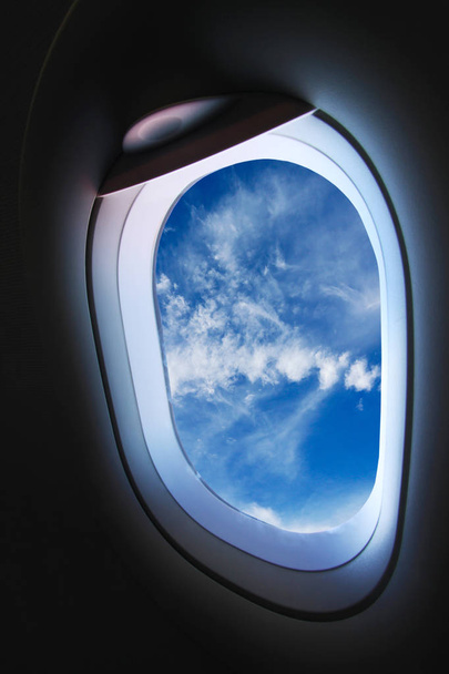 Vliegtuig venster en zicht vanuit vliegtuig op ergens, vliegtuig venster met de mening van mensen in reis naar ergens, weergave plane en achtergrond van het venster van de vliegtuig uit de lucht, reizen bedrijf met vliegtuig van verplaatsing trip. - Foto, afbeelding