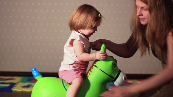 dziecko siedzi na koniu zabawka - Materiał filmowy, wideo