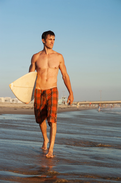 active young surfer holding a surfboard - Foto, Imagem