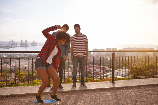 young friends with skateboard on bridge - Фото, изображение