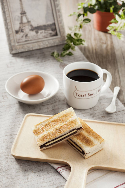 Delicioso café da manhã com torrada, ovo e café preto em uma prancha
 - Foto, Imagem