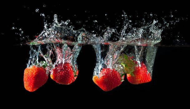 Strawberries splashing into water  - Foto, imagen