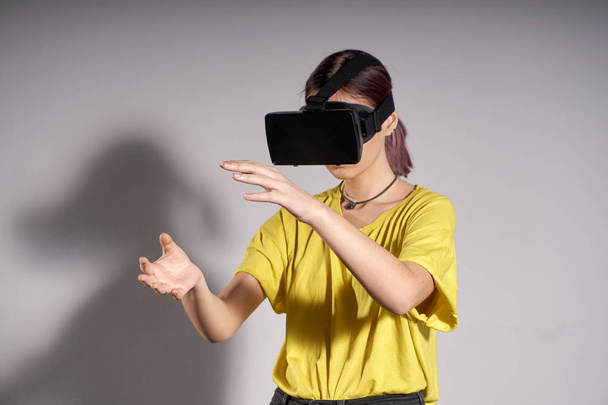 Woman in VR glasses looking up and touch objects - Fotoğraf, Görsel