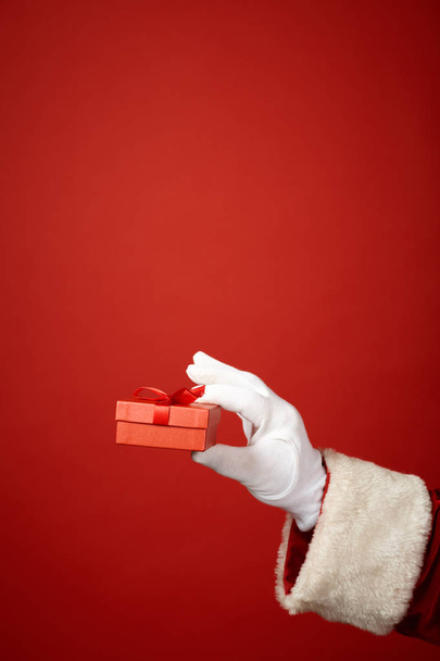 Santa Claus holding a little gift box - Фото, изображение