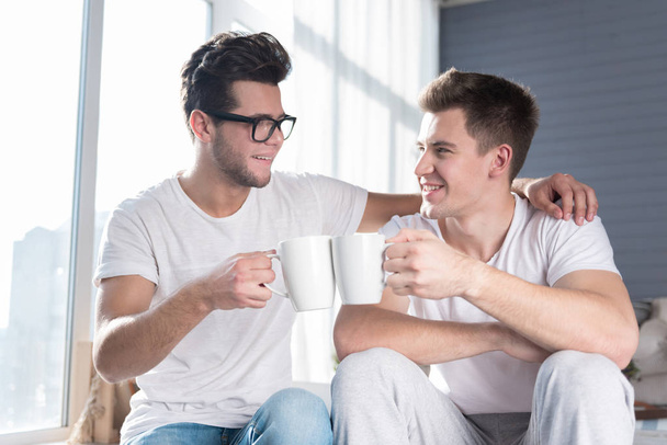 Homosexual couple having a hot drink together. - Fotó, kép