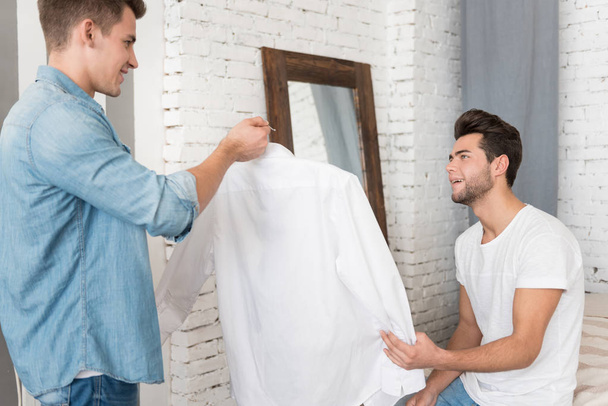 man giving a shirt to his boyfriend. - Фото, изображение