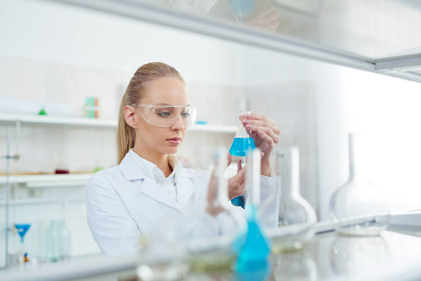 vrouw testen nieuwe stof in lab - Foto, afbeelding