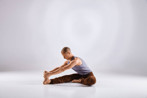 man doen yoga geïsoleerd op witte achtergrond - Foto, afbeelding