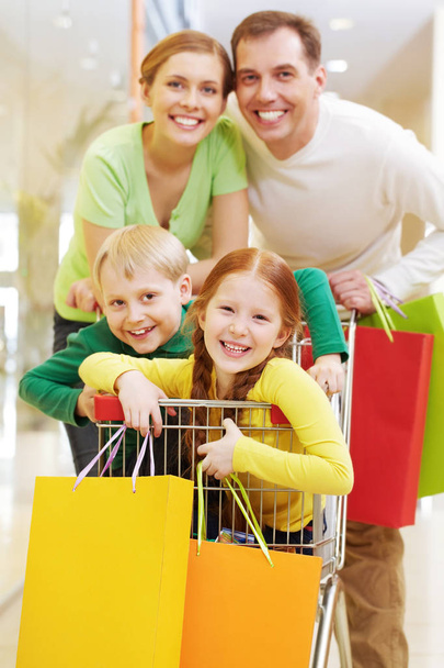 parents with their children in shopping cart  - Photo, Image