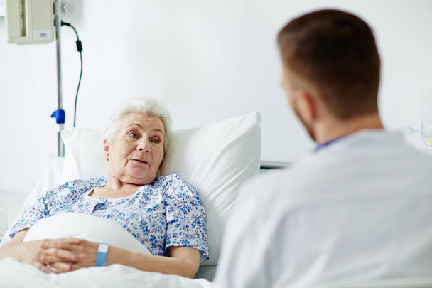 Starszy pacjent mówi do swojego lekarza - Zdjęcie, obraz