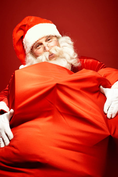 Santa Claus embracing a big sack - Фото, зображення