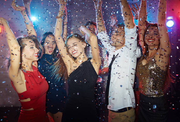 Freunde tanzen mit erhobenen Händen in Disco  - Foto, Bild