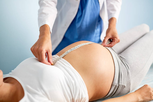 Tomando medidas de mulher grávida
 - Foto, Imagem