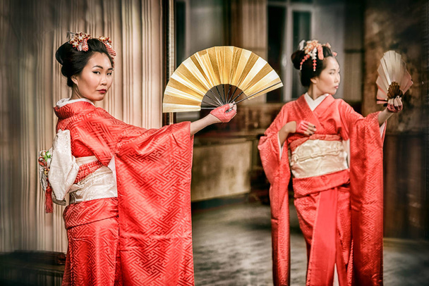 fan ile geleneksel kırmızı kimono içinde geyşa aynaya yakın: - Fotoğraf, Görsel