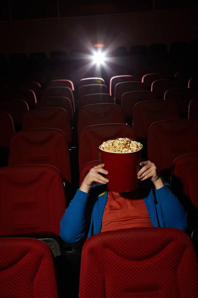 man hiding behind popcorn bucket - Foto, Imagem