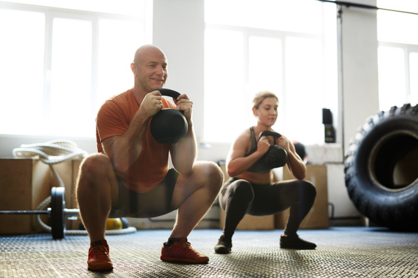  man and woman exercising with kettle bells - Photo, Image
