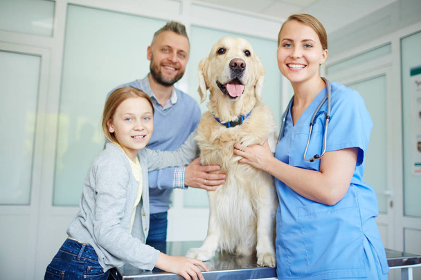 Friendly veterinarian, dog and his owners  - Photo, Image