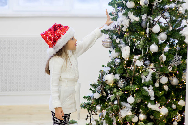 Girl decorate the Christmas tree - Foto, imagen