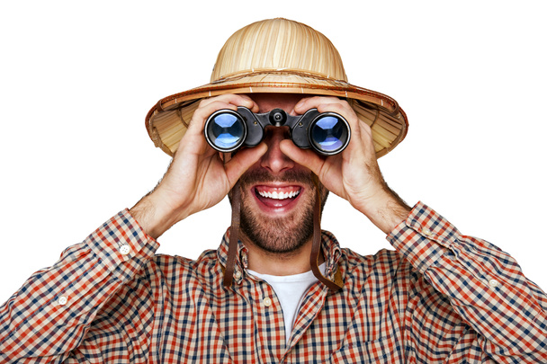 Hombre mirando prismáticos con sombrero de viajero aislado sobre bac blanco
 - Foto, Imagen