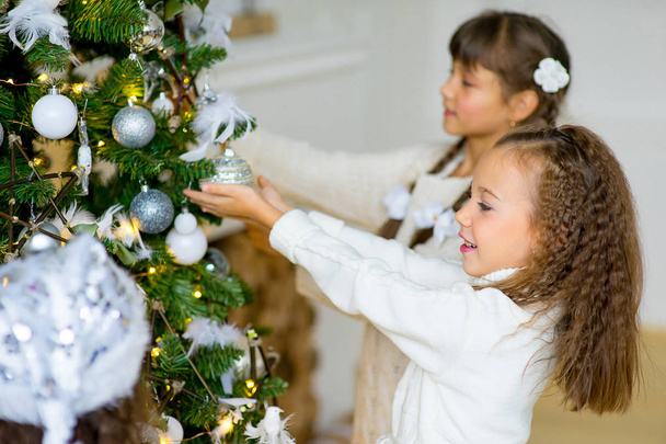 Two girls decorate the Christmas tree - Foto, immagini
