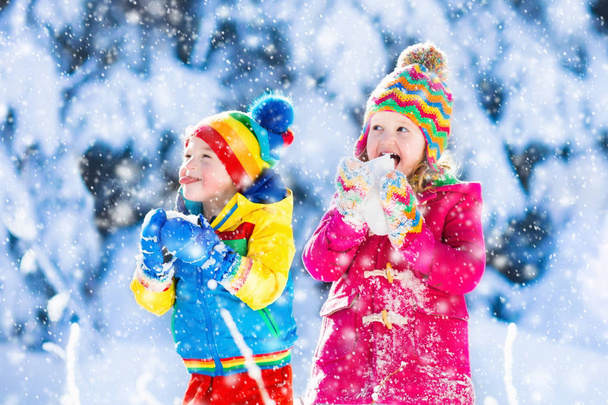 Τα παιδιά διασκεδάζουν στο χιονισμένο χειμώνα πάρκο - Φωτογραφία, εικόνα