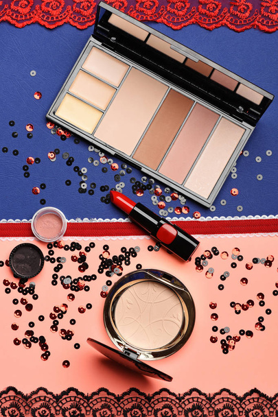 Red lipstick, cosmetic powder on colorful background - Foto, Bild