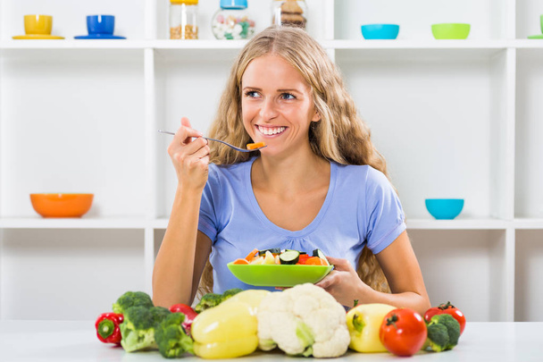 Beautiful girl eating vegetable salad - Фото, изображение