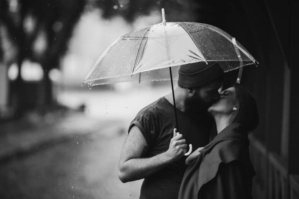 jongen en het meisje kussen onder een paraplu - Foto, afbeelding