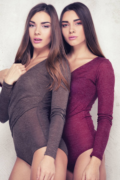 Beautiful sister twins posing in studio. - Photo, Image