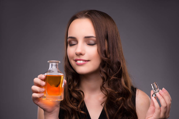 Jonge vrouw met fles parfum - Foto, afbeelding