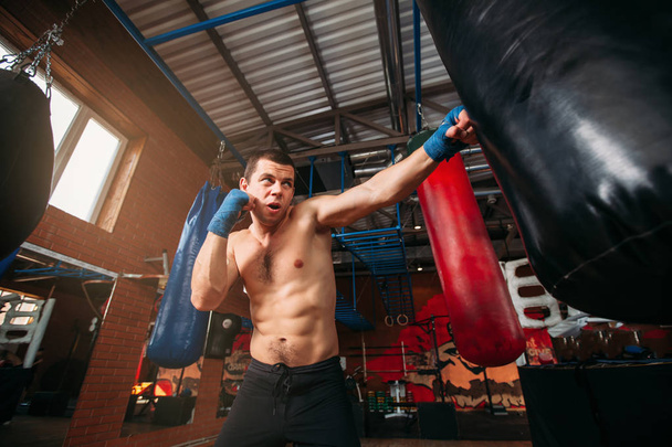 Entrenamiento muscular boxeador con saco de boxeo
 - Foto, Imagen