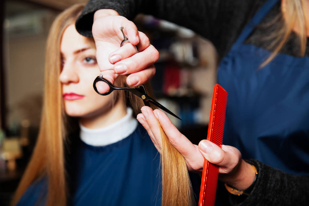 Hairdresser making hairstyle with scissors - Photo, Image