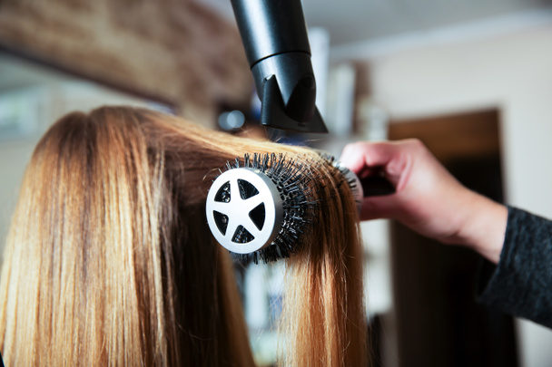Hacer peinado usando secador de pelo
 - Foto, imagen