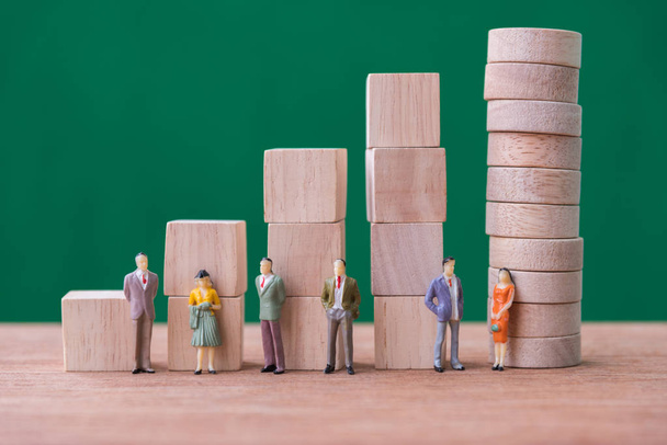 miniature people stand on stack of wood cube building blocks - Zdjęcie, obraz