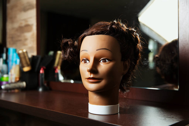 Hairdressing mannequin on wooden table - Photo, Image