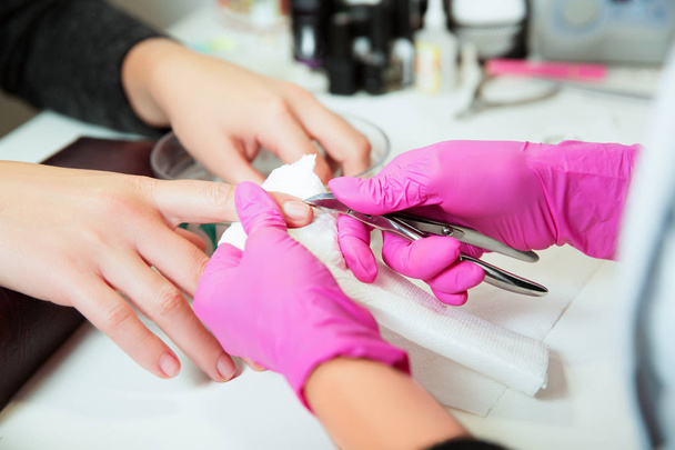 Manicure specialist in gloves making procedure - Photo, Image
