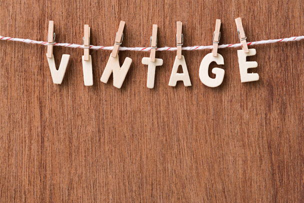 wood text VINTAGE hanging with clothespins on wooden background - Photo, image