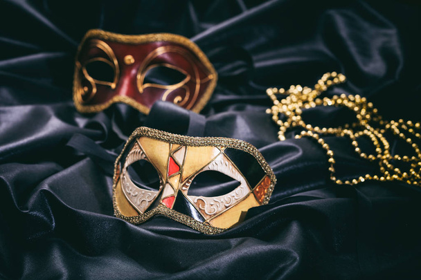 Μάσκες καρναβαλιού σε μαύρο σατέν φόντο - Φωτογραφία, εικόνα