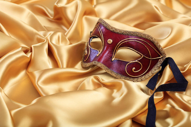 Máscara de carnaval isolada em fundo de cetim dourado
 - Foto, Imagem