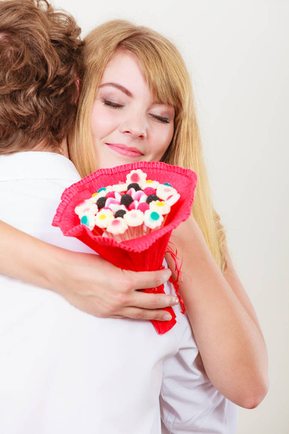 Couple with candy bunch flowers hugging. Love. - Фото, зображення