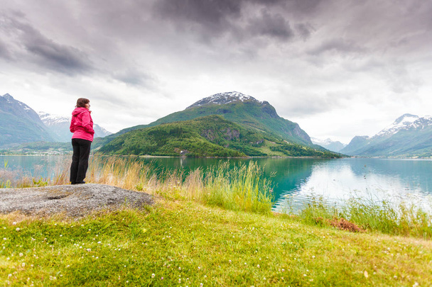 Woman tourist relaxing on fjord sea shore, Norway - 写真・画像