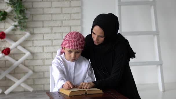 Arabische Mutter und Sohn posieren drinnen und lesen Buch - Filmmaterial, Video