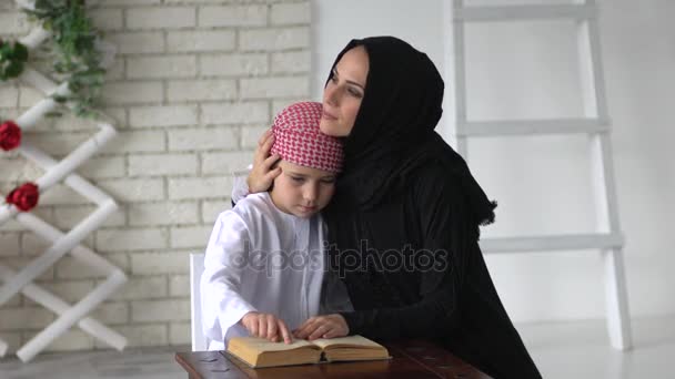 Arabische moeder en zoon poseren binnen en lezen boek - Video