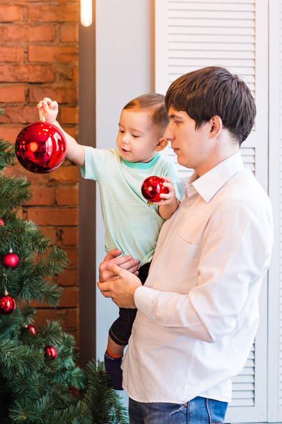 息子とパパの自宅リビング ルームでクリスマス ツリーを飾る - 写真・画像