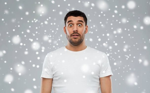 scared man in white t-shirt over snow - Foto, Imagem