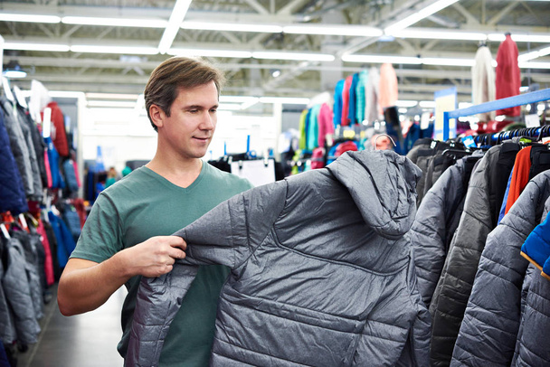 Man chooses winter jacket in store - Foto, Imagem