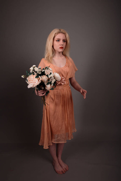 Living doll girl with flowers on a gray background - Foto, Bild