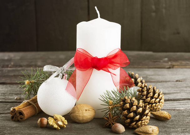 Festive candles, fir-tree, pine cones, nuts on a wooden backgrou - Photo, image