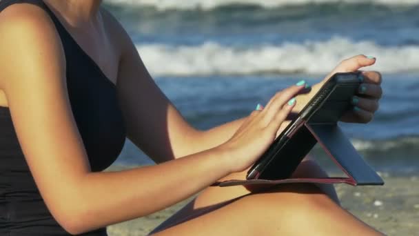 Woman writing an email on a tablet pc by the sea - Video, Çekim